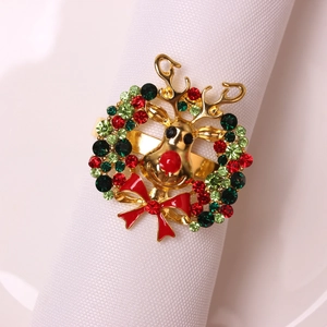 Golden reindeer Christmas napkin ring with colorful rhinestones on white fabric