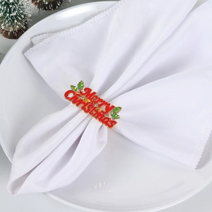 Red Merry Christmas napkin ring with green holly leaves and crystals on white cloth