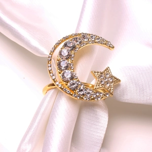 Detailed close-up of a gold moon and star napkin ring with sparkling rhinestones