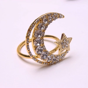 Detailed view of gold star and moon napkin ring featuring sparkling rhinestones