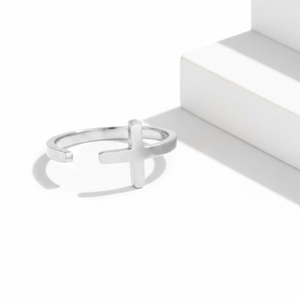 Adjustable silver stainless steel cross ring with a matte finish on geometric stairs