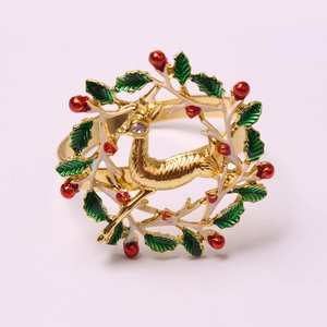 Christmas reindeer napkin ring featuring golden wreath with red berries and green leaves