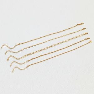 Detailed set of five different gold plated Figaro and ball chain bracelets with lobster clasps