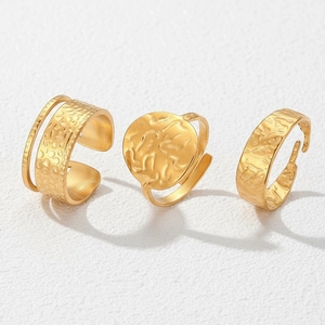 Detailed view of three-piece gold irregular hammered rings with adjustable open bands