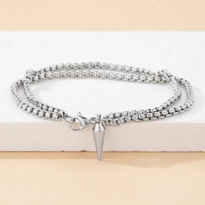 Dettaglio del bracciale a doppia catena a sfere argentate con pendente a punta lucida e moschettone