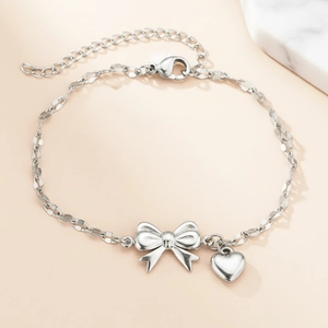 Elegant silver stainless steel bracelet featuring bow charm and small heart pendant