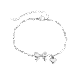 Macro shot of silver stainless steel bow and heart charms on a double-layer chain