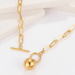 Macro view of gold stainless steel paperclip chain with OT toggle clasp and ball pendant