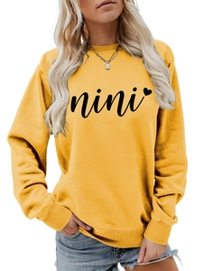Close-up of ginger yellow crewneck sweatshirt with black nini heart print detail