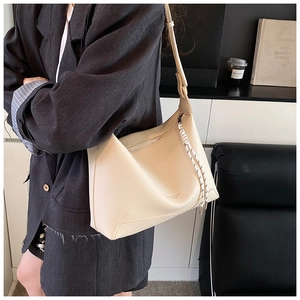 Close-up of cream lychee texture hobo bag with a decorative woven rope zipper pull