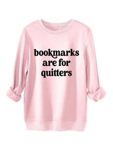 Detail of pink sweatshirt cuff and 'Bookmarks Are For Quitters' print on fabric