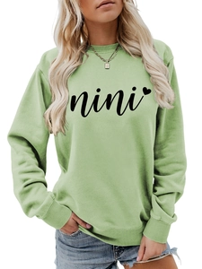 Detail of the sage green sweatshirt showing ribbed neckline and nini heart print