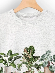 Close-up of crew neck sweatshirt with detailed potted plant print on light grey fabric