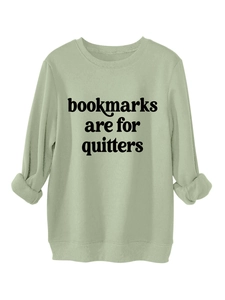 Detail of light green sweatshirt fabric and 'bookmarks are for quitters' text design