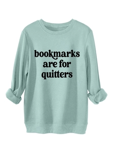 Detail of mint green sweatshirt featuring bookmarks are for quitters bold print