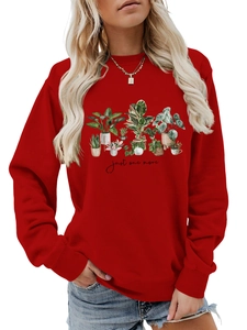 Detail of red crewneck sweatshirt featuring floral potted plant prints and text
