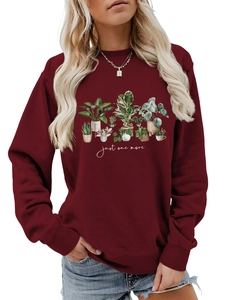 Macro detail of wine red crewneck sweatshirt with botanical potted plant illustration