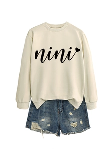 Detail of beige nini heart sweatshirt and distressed denim shorts casual outfit set