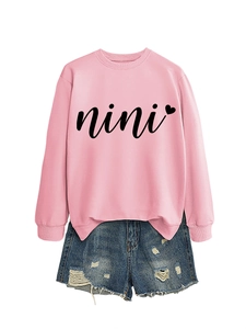 Flat lay of pink nini heart sweatshirt and distressed blue denim shorts set