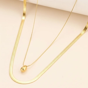 Detailansicht der lagigen goldenen Schlangenkette mit zartem Perlenanhänger-Set