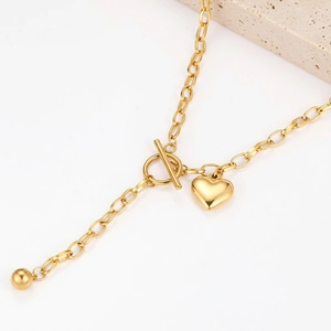 Macro di un ciondolo a cuore in oro 18K con chiusura OT su una raffinata catena a Y