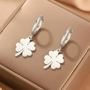 Pendientes de trébol de acero inoxidable plateado pulido en un joyero de cuero marrón