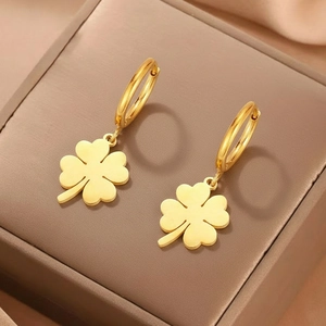 Elegantes pendientes de trébol de acero inoxidable dorado sobre cuero oscuro