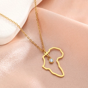 Collana con mappa del mondo dorata e zircone blu su elegante sfondo di seta