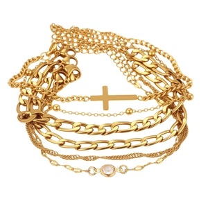 Détail de chaînes multicouches en acier doré avec pendentif croix et zircone