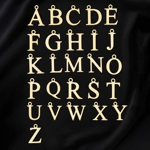 Grille détaillée de 26 pendentifs alphabet en acier inoxydable doré 18K sur tissu noir
