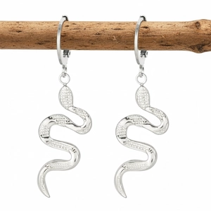 Silver stainless steel snake pendant hoop earrings displayed on a rustic wood branch