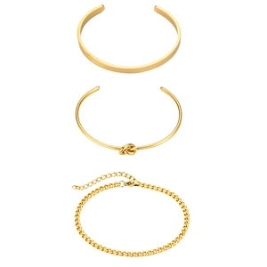 Close-up of three gold stainless steel bracelets including minimalist knot and curb chain