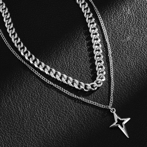 Double-layered silver necklace featuring a Cuban link chain and a hollow star pendant