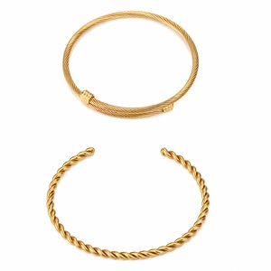 Detail of two gold-plated stainless steel bangles with twisted cable and rope texture