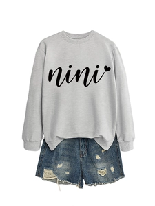 Detail of grey nini heart sweatshirt and distressed light blue denim shorts