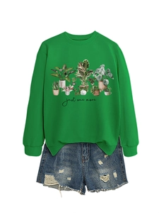 Detail of bright green sweatshirt featuring potted plant graphics and handwritten text