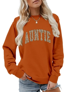 Détail du sweat-shirt orange montrant le lettrage AUNTIE léopard et les poignets côtelés