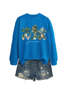 Detail view of royal blue sweatshirt with floral plant prints and white script text