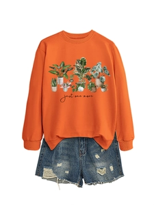 Detail of orange crewneck sweatshirt featuring watercolor potted plant prints and text