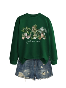 Detail of green crewneck sweatshirt featuring potted plant graphics and ribbed cuffs
