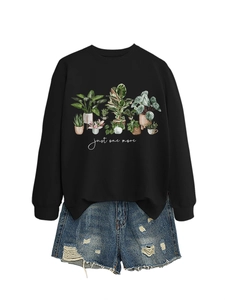Detail of a black crewneck sweatshirt featuring a watercolor potted plant print and text