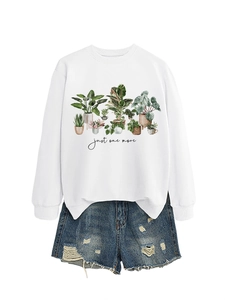 Detail of white crewneck sweatshirt with botanical plant print and distressed denim shorts