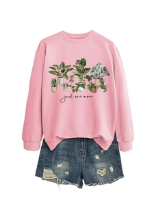 Flat lay of a pink sweatshirt featuring plant illustrations and frayed denim shorts