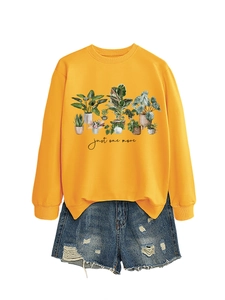 Detail of yellow sweatshirt with botanical plant print and just one more lettering