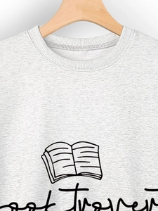 Close-up of light grey knit sweatshirt featuring a minimalist book and floral print detail