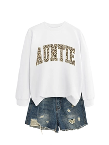 Mise à plat de sweat blanc avec texte AUNTIE léopard et short en jean bleu déchiré