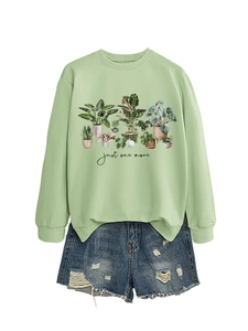 Detail view of mint green crewneck sweatshirt with botanical print and denim shorts