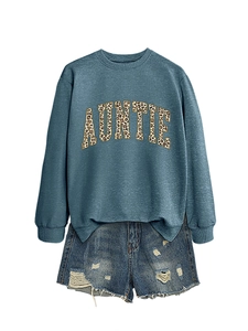 Détail d'un sweat bleu col rond avec texte Auntie léopard et un short en jean