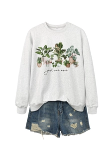 Detailed flat lay of a grey crewneck sweatshirt with potted plants print and denim shorts