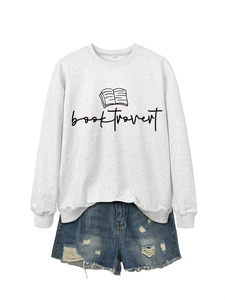 Flat lay of gray Booktrovert sweatshirt paired with distressed denim shorts and print